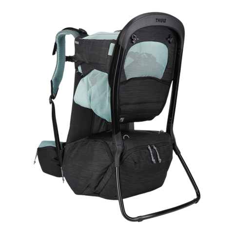 A Thule baby carrier backpack in black and light teal, shown from a three-quarter rear view against a solid white background.
